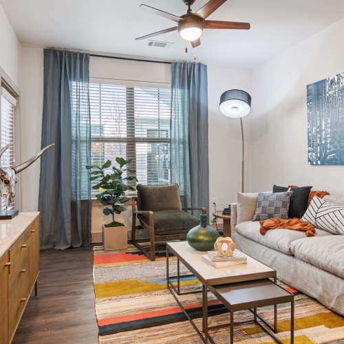Model living room at our apartments in Midland, TX, featuring wood grain floor paneling and a large window.  Model living room at our apartments in Midland, TX, featuring wood grain floor paneling and a large window.
