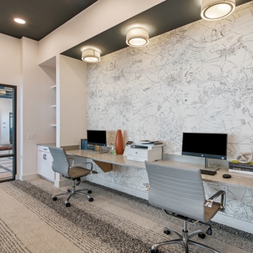 Co working space at our apartments in Midland, featuring a long wall-desk with two desktop computers and grey office chairs. Co working space at our apartments in Midland, featuring a long wall-desk with two desktop computers and grey office chairs.