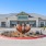 The entrance to our apartments in Midland, TX, featuring a drop off area, a metal sculpture, and a sign reading 