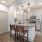 Model living room and kitchen at our apartments in Midland, featuring wood grain floor paneling and counter seating.